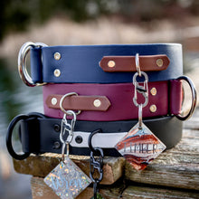 Load image into Gallery viewer, A stack of Namekagon Collars. The top one is Deep Sea color, the middle one is Huckleberry, and the bottom is black and white